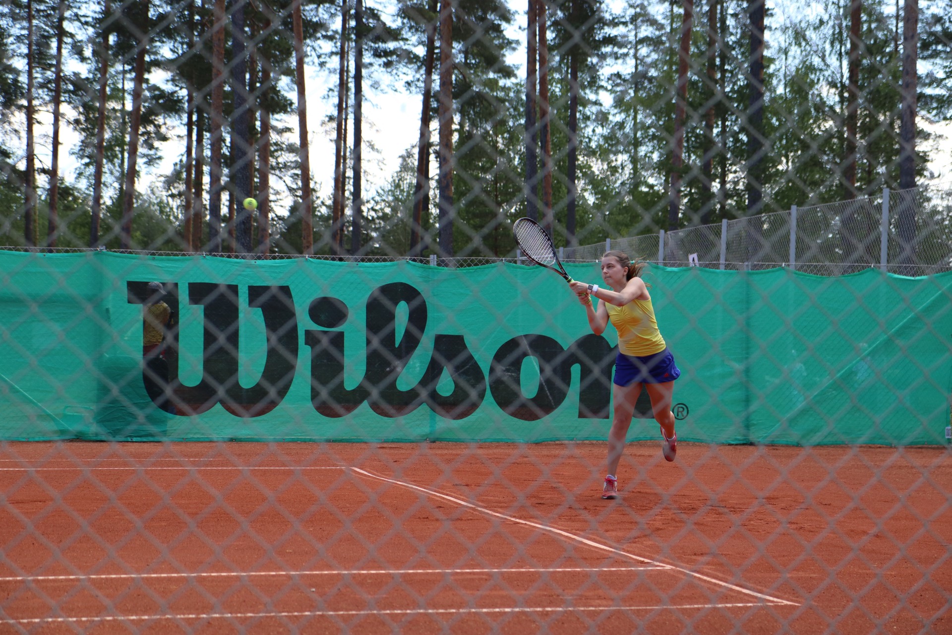 Elena taking the ball early with a backhand from the baseline