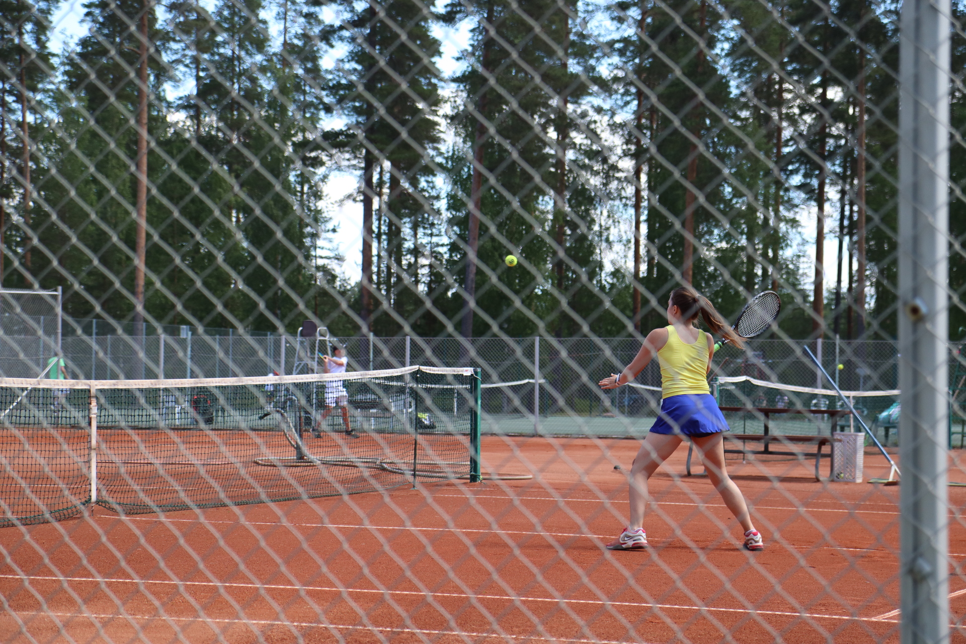 Elena finishing the point at the net with a forehand volley